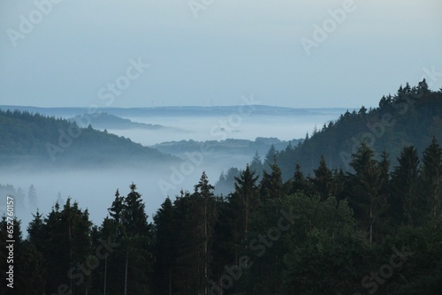 Scenic view of a beautiful landscape with valleys and mountains seen on a foggy day