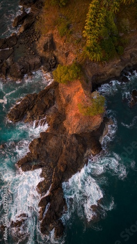 Aerial view of ocean waves splashing on rocks