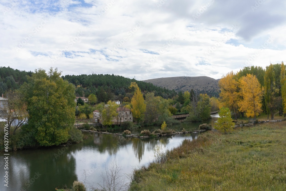 Views of the Duero river as it passes through the city of Soria on an autumn day with yellowing tree