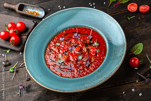 Cold soup of tomatoes, baked peppers. Menu for a restaurant. Beautiful composition on wooden boards.