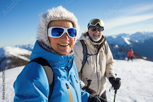 An elderly couple enjoying their winter holidays together captures their joyful moments by taking a selfie on a snowy mountainside.