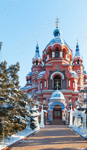 Irkutsk in winter holidays. City landmark - Cathedral of Kazan Icon of Mother of God during Christmas. Сourtyard of cathedral is decorated with ice sculptures and Christmas tree