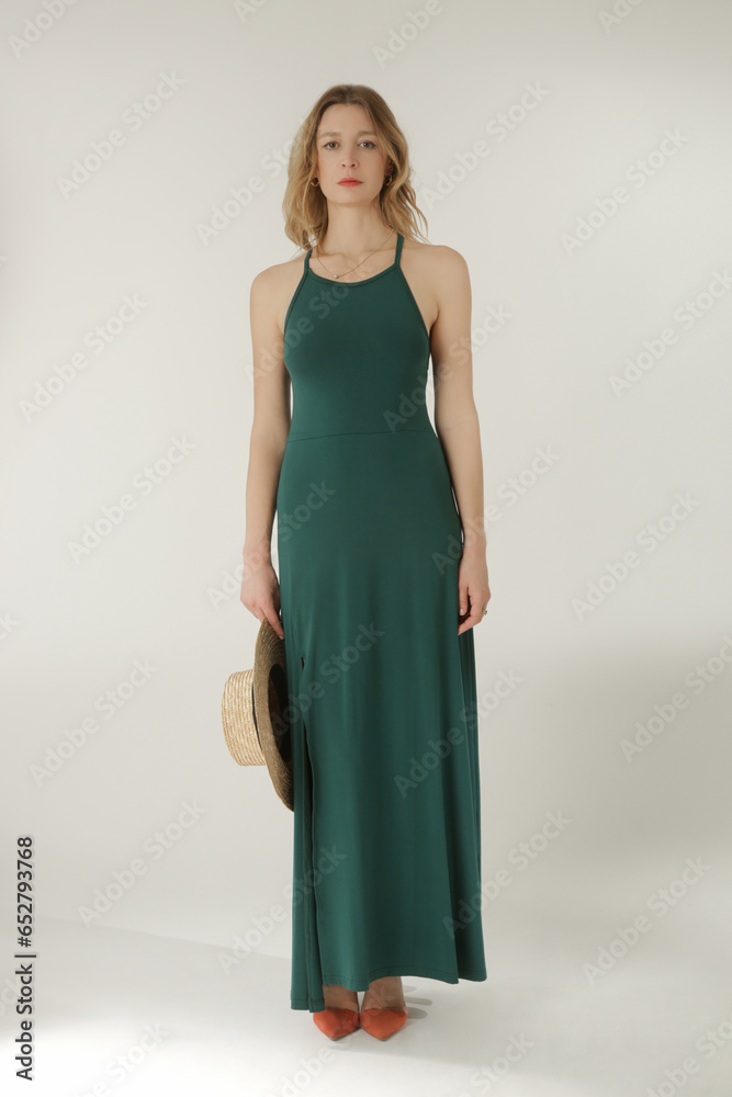 Studio fashion portrait of female model in long tight green jersey dress Studio fashion portrait of female model in long tight green jersey dress