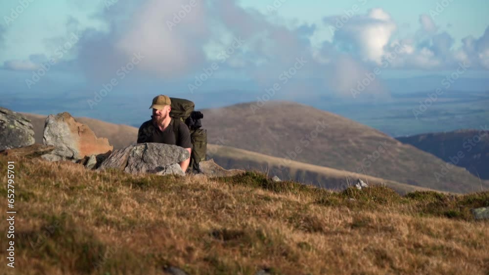 A backpacker climbing up through a gorgeous mountain landscape in the UK A backpacker climbing up through a gorgeous mountain landscape in the UK