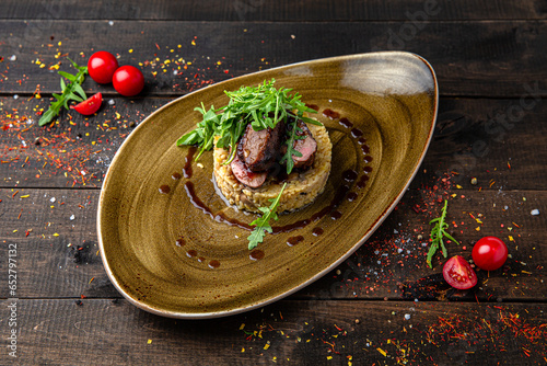 Risotto with mushrooms and beef steak. Menu for a restaurant. Beautiful composition on wooden boards.