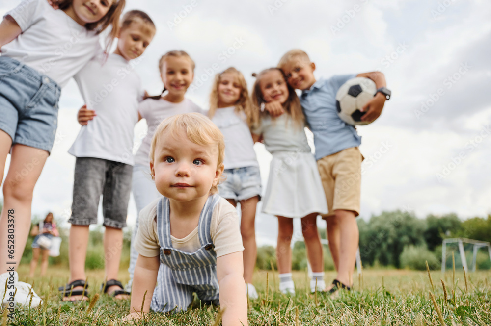 Cute little boy. Kids are having fun on the field at daytime together Cute little boy. Kids are having fun on the field at daytime together