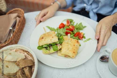 Healthy chicken and spinach sandwiches and fresh vegetable salad on the table at city cafe. Healthy diet food concept. for breakfast or lunch. Vegetarian food. Vegan menu. Long banner format. High