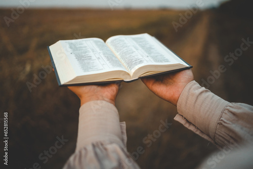 Bible in hands in nature, Christian concept