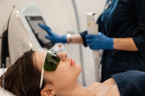 Getting photo rejuvenation procedure at cosmetology clinic. Women in beauty salon