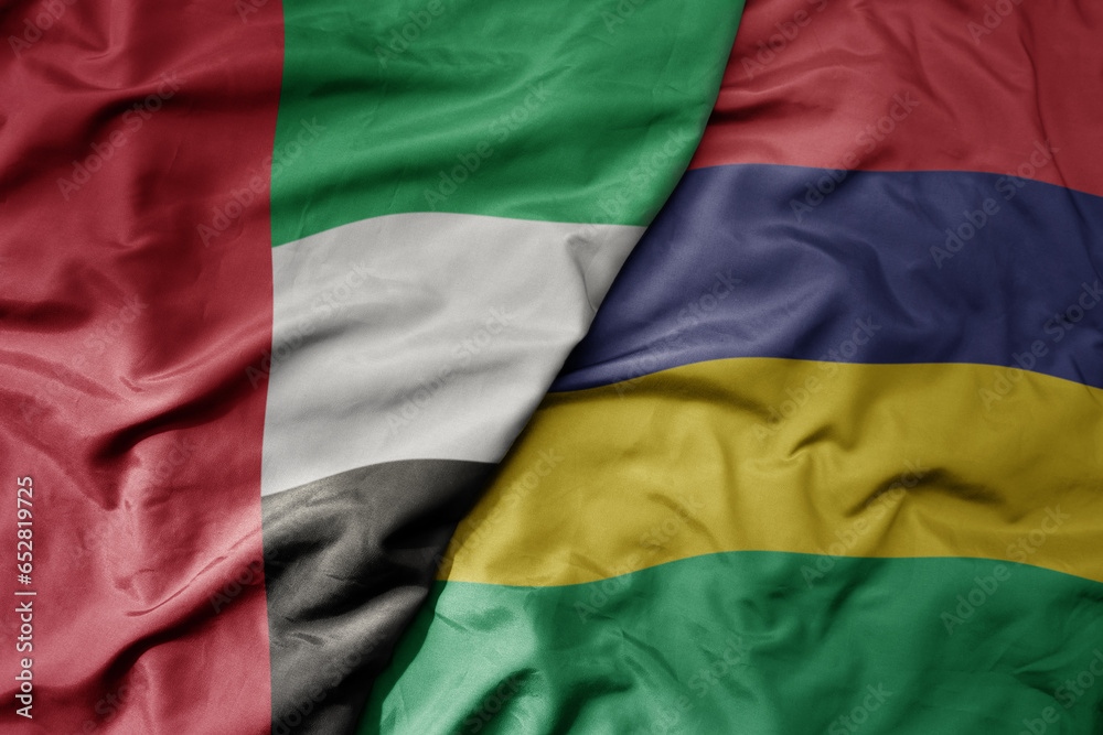 big waving realistic national colorful flag of united arab emirates and national flag of mauritius .