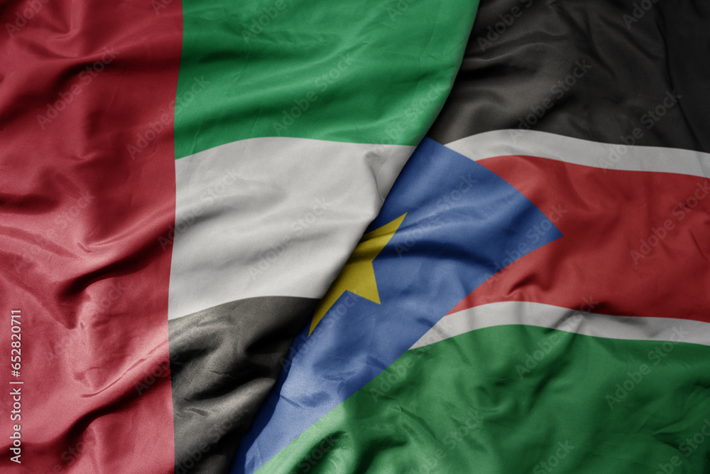 big waving realistic national colorful flag of united arab emirates and national flag of south sudan .