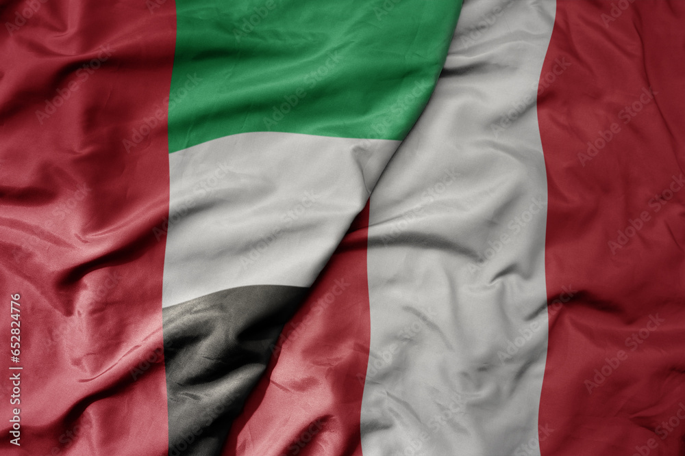 big waving realistic national colorful flag of united arab emirates and national flag of peru .