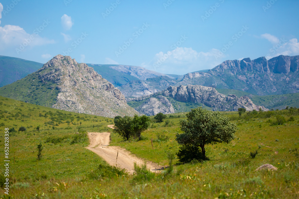Beautiful highlands nature landscape in summer. Panoramic view of the mountains in the distance, blue clouds over the mountains. Long banner of mountain panorama.