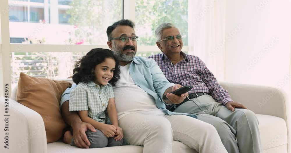 Multi-generational men spend time together switch channels, enjoy movie using on-line digital streaming TV on weekend at home. Cute little boy with grandpa and great-grandad watch cartoons on leisure Multi-generational men spend time together switch channels, enjoy movie using on-line digital streaming TV on weekend at home. Cute little boy with grandpa and great-grandad watch cartoons on leisure