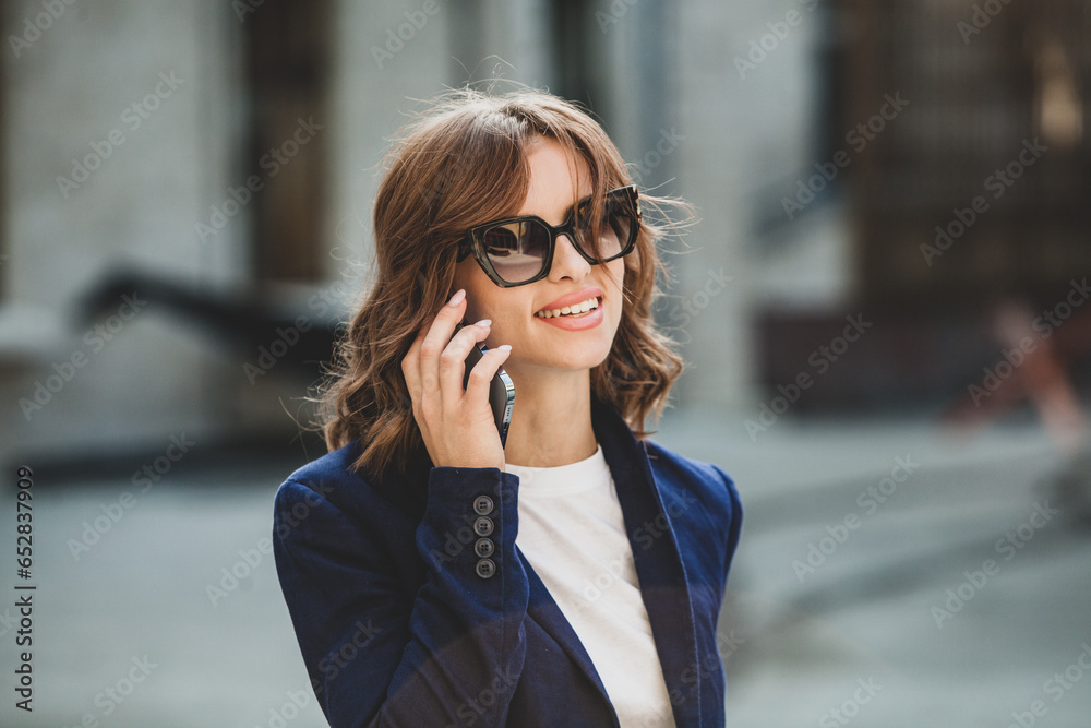 Portrait of a successful business woman in front of modern business building. Young manager poses outside. Woman employee of an office. Portrait of a successful business woman in front of modern business building. Young manager poses outside. Woman employee of an office.