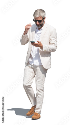 Elegant grey-haired man in a white suit walking in summer isolated on white background