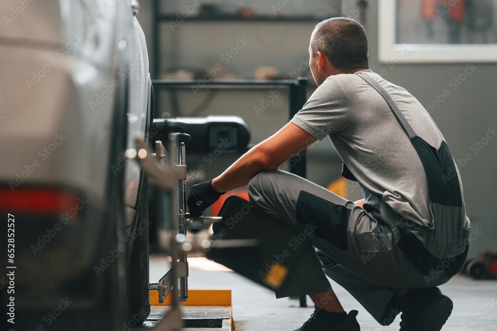 Changing the tire. Man is works in the automobile repairing salon Changing the tire. Man is works in the automobile repairing salon
