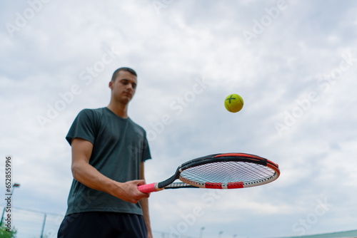 young tennis player coach hitting the ball with a racket on the tennis court preparing for the competition sports lifestyle © Guys Who Shoot