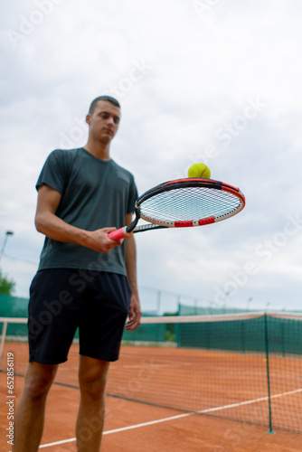 young tennis player coach hitting the ball with a racket on the tennis court preparing for the competition sports lifestyle © Guys Who Shoot