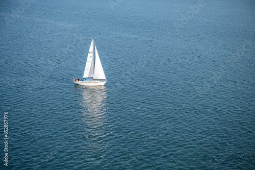 Beautiful white sailboat at Kiel, Germany on the sea with reflection on water surface