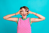 Photo of overjoyed cheerful girl open mouth wear checkered trendy clothes cover eyes have fun isolated on cyan color background