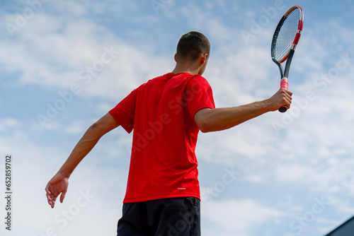 portrait of young professional tennis player after championship or competition on tennis court with racket in hands back view © Guys Who Shoot