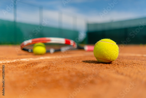 close-up of sports equipment, tennis rackets and balls lie on an outdoor ground court hobby competition sport © Guys Who Shoot