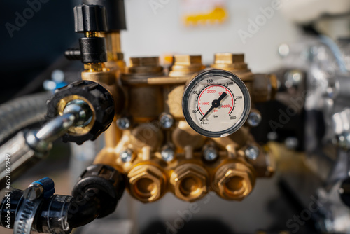 Water pressure gauge close up with valves and engine