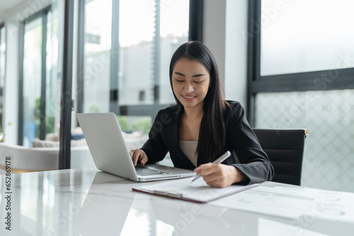 Beautiful confident asian business woman working with laptop Hands typing  keyboard. Professional investor working new start up project. business planning in office. Technology business
