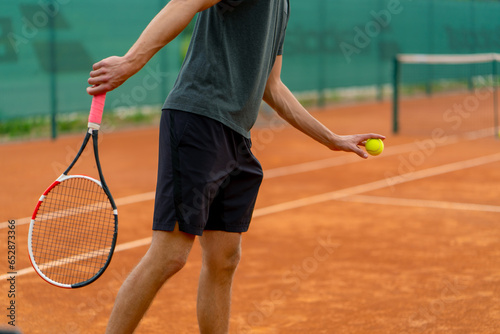 young professional player coach on outdoor tennis court practices strokes with racket and tennis ball © Guys Who Shoot