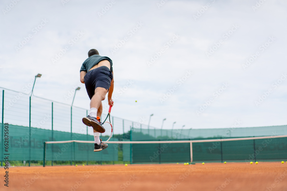 Obraz premium young professional player coach on outdoor tennis court practices strokes with racket and tennis ball