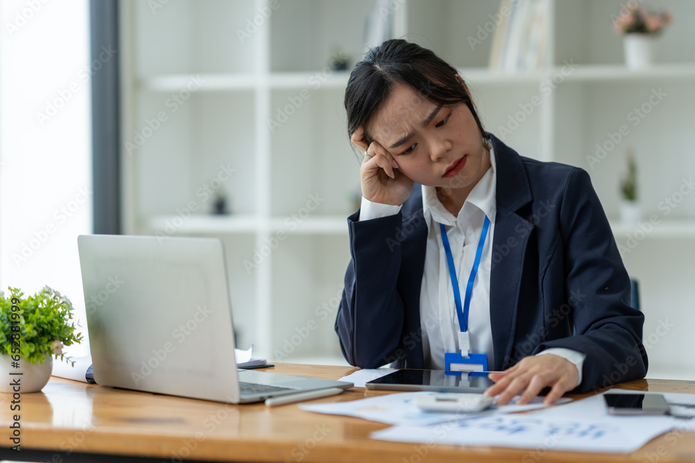 Young Asian businesswoman tired from working long hours, stressed, tired of thinking. Ideas for planning, presenting financial reports, investments, business plans, modern concepts online. Young Asian businesswoman tired from working long hours, stressed, tired of thinking. Ideas for planning, presenting financial reports, investments, business plans, modern concepts online.