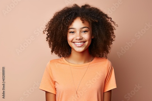portrait beautiful afro american teenager girl dressed in t-shirt and smiling, light background photo