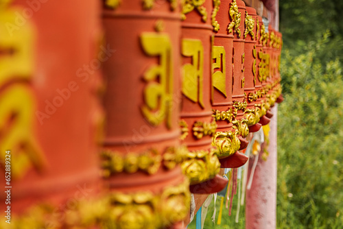 Rotating religious elements for touching turning spinning Buddhist prayer wheel at Buddhist monastery. Prayer wheels in Buddhist stupa temple. Buddhism religion concept