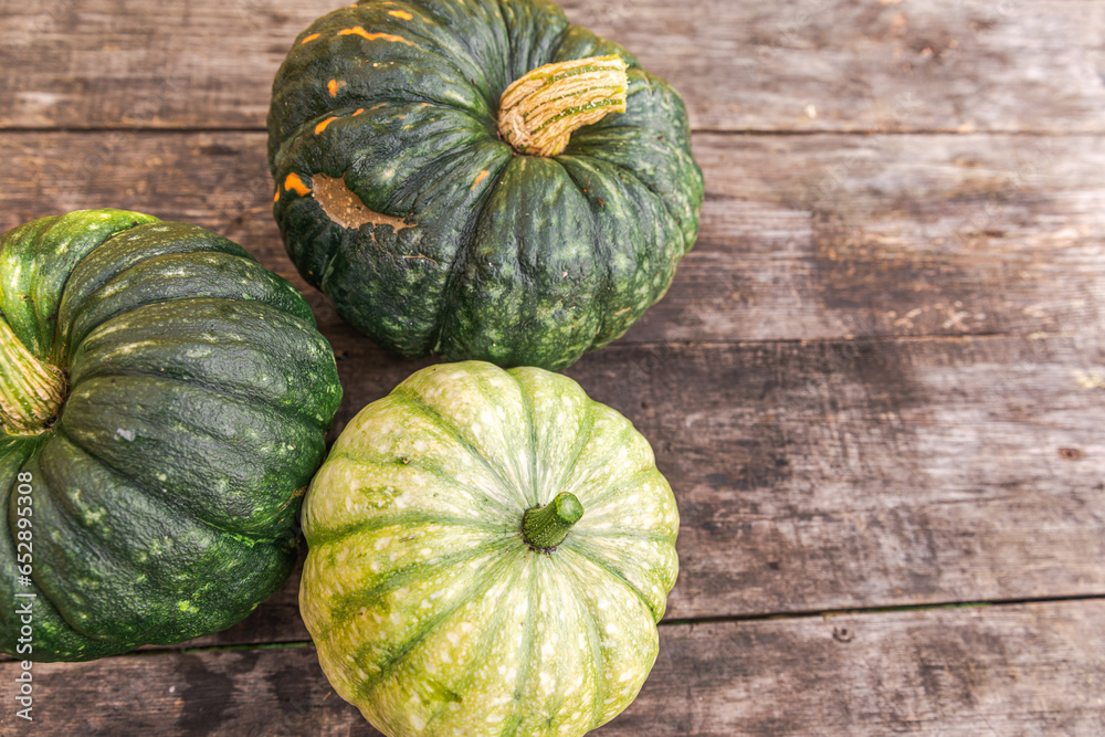 Autumnal Background. Natural autumn fall view pumpkins on wooden background. Inspirational october or september wallpaper. Change of seasons ripe organic food concept. Halloween party Thanksgiving day Autumnal Background. Natural autumn fall view pumpkins on wooden background. Inspirational october or september wallpaper. Change of seasons ripe organic food concept. Halloween party Thanksgiving day