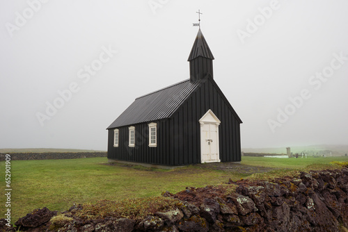 Veiled in fog, Iceland's black church stands as a solemn sentinel, echoing mysteries of ages past. photo