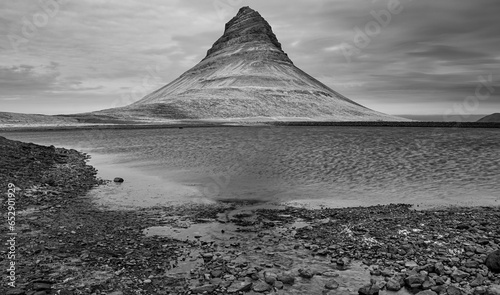 Kirkjufell's shadowed reflection, a monochrome memory where land, water, and clouds entwine. photo