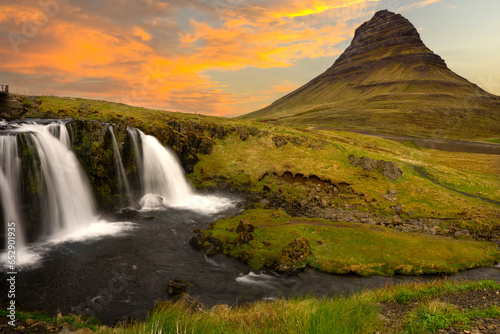 Twilight whispers at Kirkjufell, where water cascades and mountains stand timeless, bathed in dusky hues.