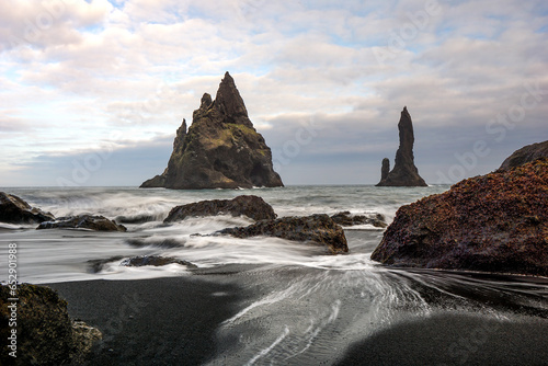 Where obsidian shores meet frothy waves: Reynisfjara's enigmatic embrace of the sea.