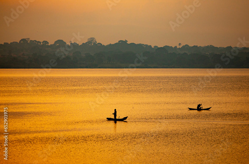 fishermen cast nets from their boats on Lake Victoria at sunrise in Uganda