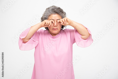 Asian senior woman with eye pain isolated on white background, Diabetic Retinopathy, Pinguecula or Pterygium concept photo