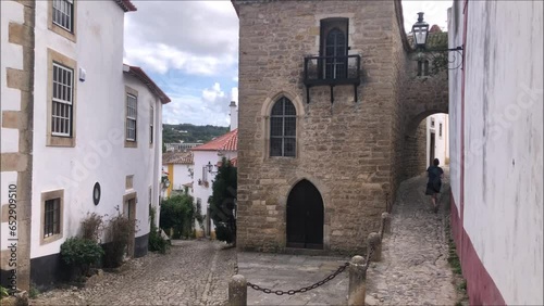 Cidade medieval de Óbidos em Portugal, com um turista a caminhar numa rua
