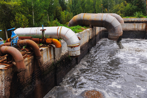 Obraz na płótnie Pipes with waste water of industry is discharged into tank of treatment plant