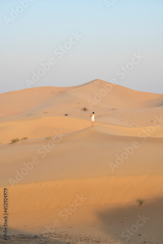 Woman taking a pictures of dunes in the desert with copy space  travel concept  desert landscape