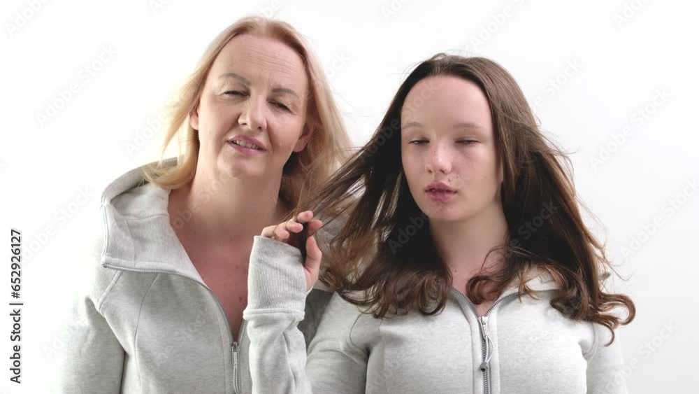 close-up faces of European women, an adult and a young girl looking into the frame, mother and daughter pointing with a finger, breaking hair. white background close-up faces of European women, an adult and a young girl looking into the frame, mother and daughter pointing with a finger, breaking hair. white background