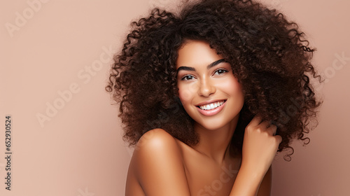 Beauty portrait of african american girl with clean healthy skin on beige background. Smiling dreamy beautiful black woman.Curly hair in afro style