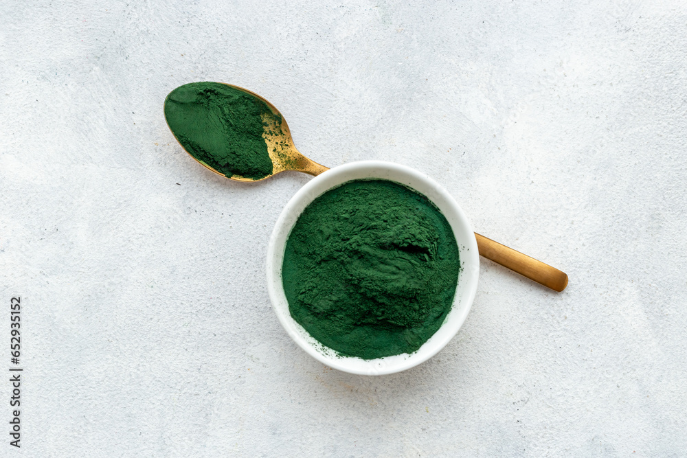 Spirulina algae powder in bowl and spoon, super food, top view Spirulina algae powder in bowl and spoon, super food, top view
