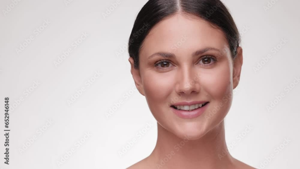 Close up portrait beautiful brunette woman. Beauty and skin care. Adorable young half-naked female look at the camera and smiling. Advertising fresh clean healthy skin care concept. Slow motion. Close up portrait beautiful brunette woman. Beauty and skin care. Adorable young half-naked female look at the camera and smiling. Advertising fresh clean healthy skin care concept. Slow motion.