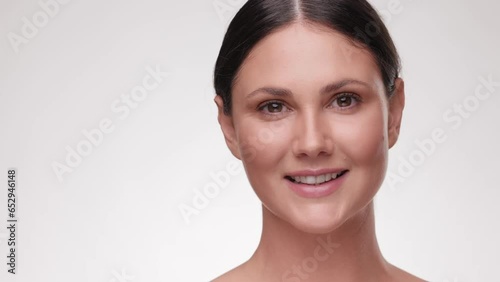 Close up portrait beautiful brunette woman. Beauty and skin care. Adorable young half-naked female look at the camera and smiling. Advertising fresh clean healthy skin care concept. Slow motion.