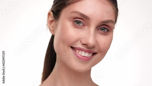 Concept for fresh moisturized elasticity skin. Young woman massaging her face. Smiling girl touching pretty face after applying cream. Natural healthy face. hydrated skin care treatment.